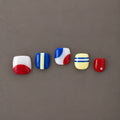 Sidewalk Pop U.P.O.N Mini hand-painted press-on nails with red, blue, yellow and white graphic designs
