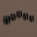 Extra Smoke by U.P.O.N: five glossy, translucent smoky-black extra-short square press-on nails on a dark taupe background